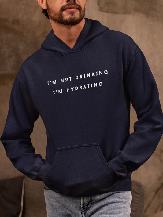 Navy hoodie with text 'I'M NOT DRINKING I'M HYDRATING' worn by a person against a brown background